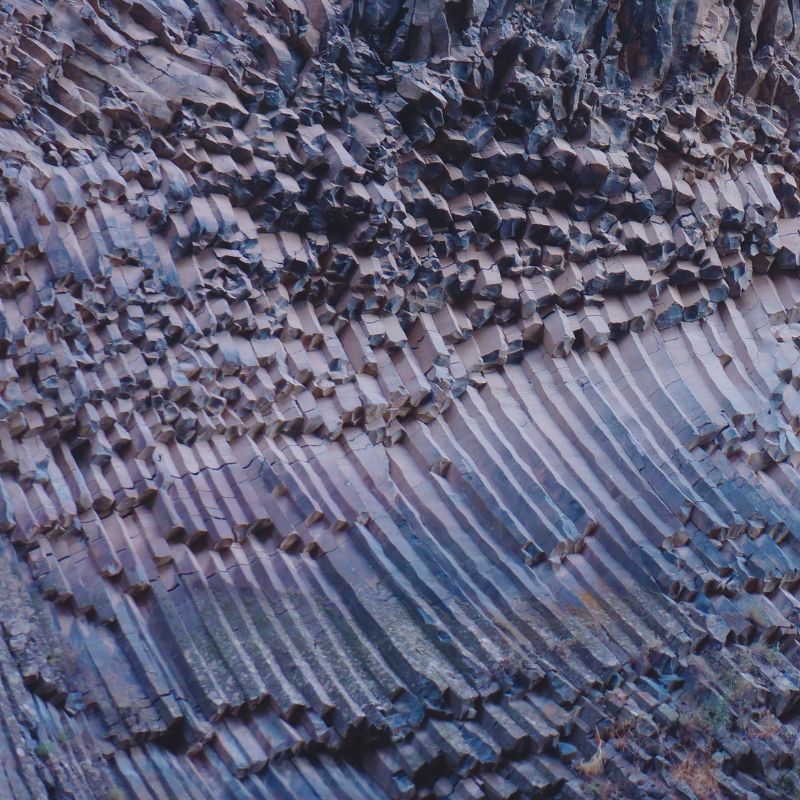 Columnar basalt formations showing natural fracture patterns in dark stone.