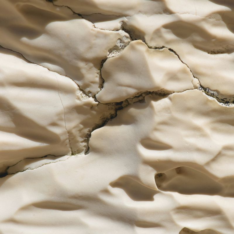 Close-up of layered carbonate rock showing natural fracture lines.